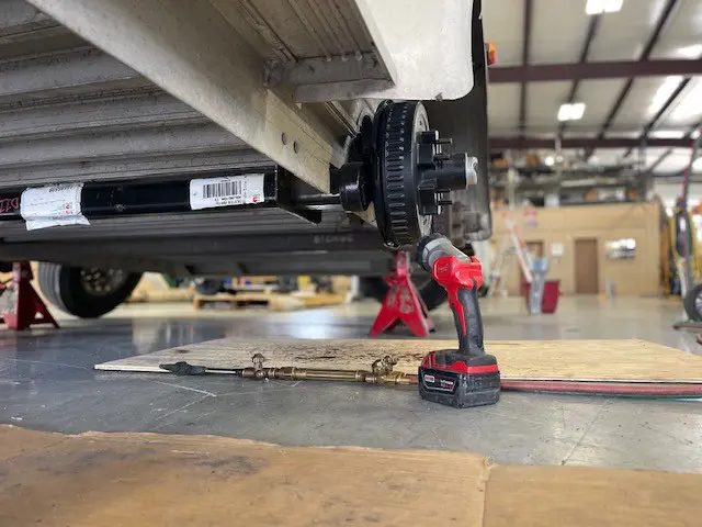 A mechanical setup with gears and a drill in an industrial space.